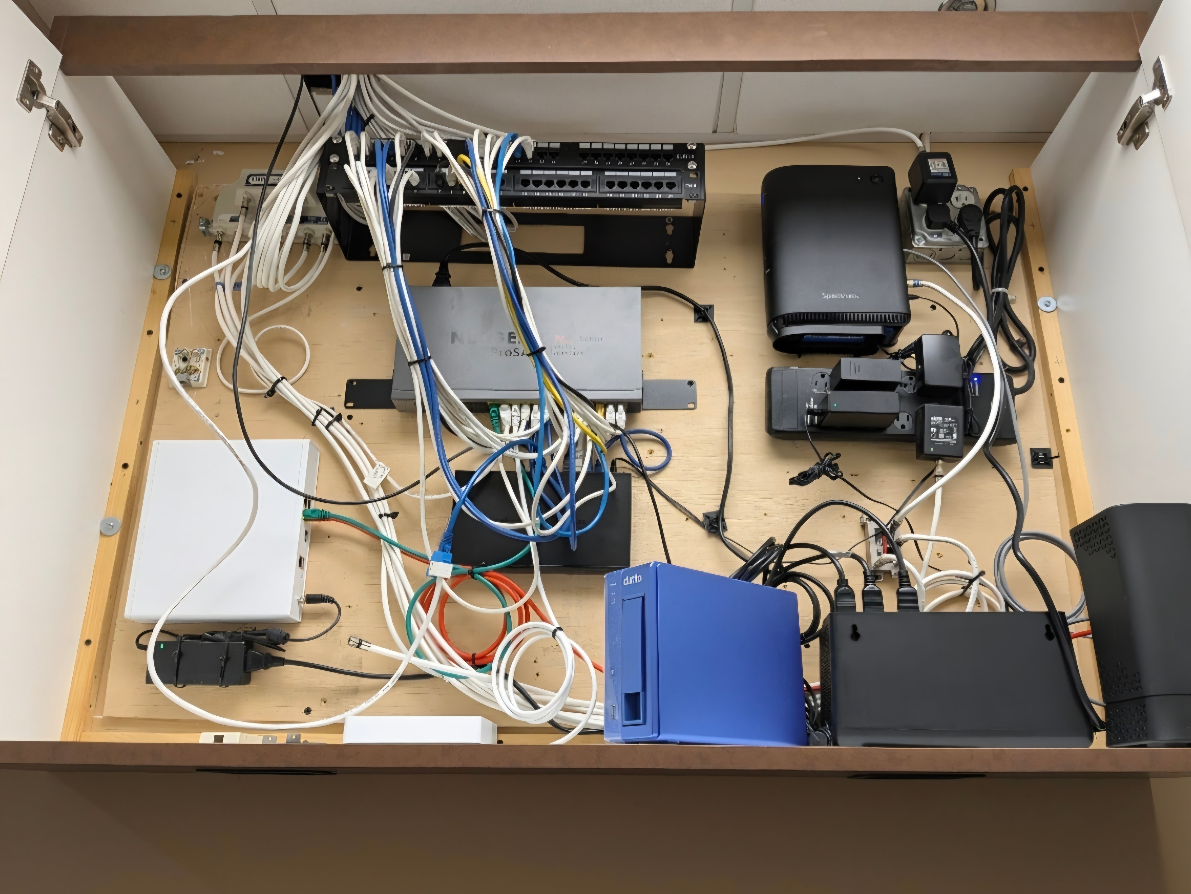 Before: chaotic wall-mounted rack with dangling cables